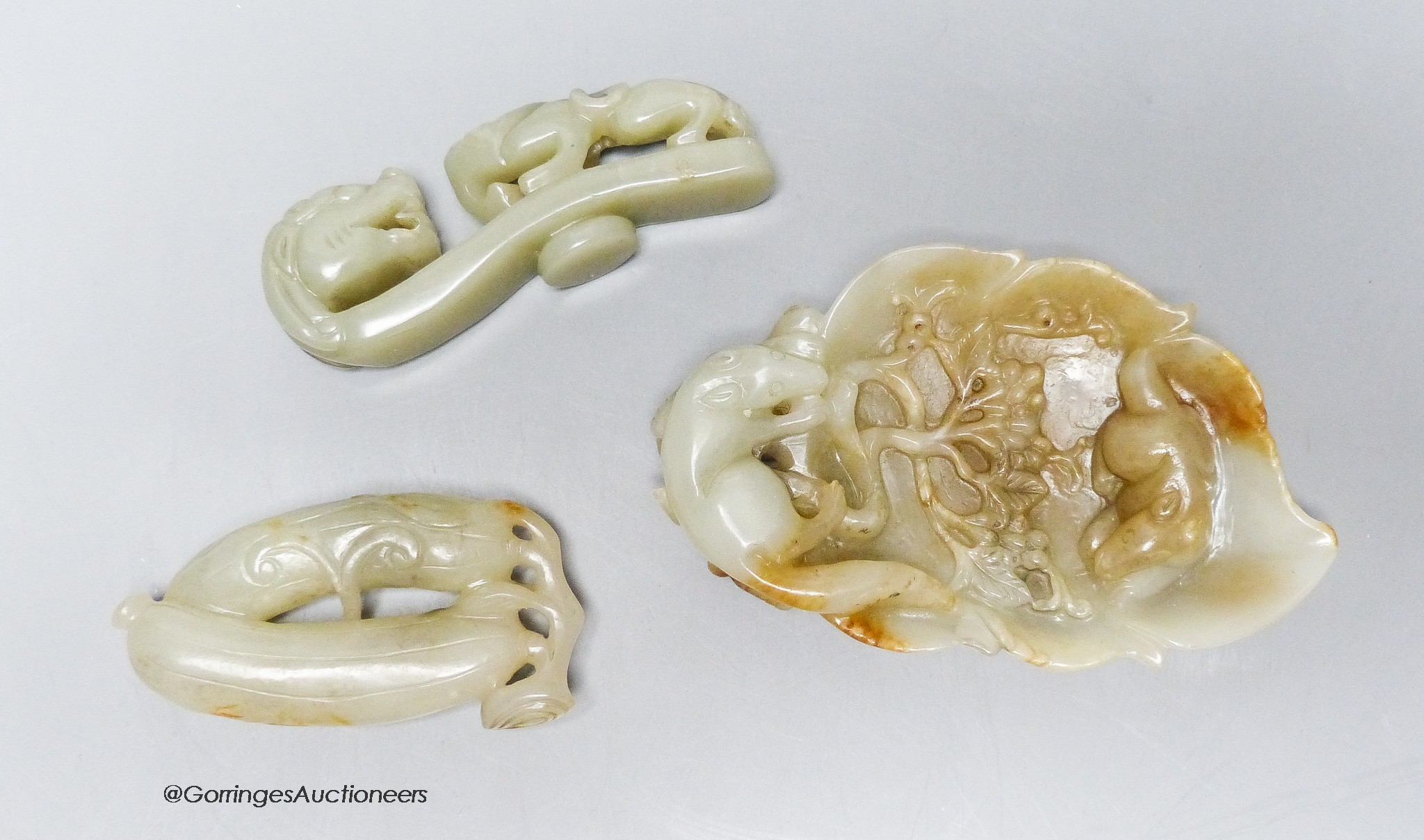 Three Chinese celadon jade carvings, a 'squirrel' brushwasher, 'dragon' belt hook and a carving of bitter melons, 7.5 - 11cm